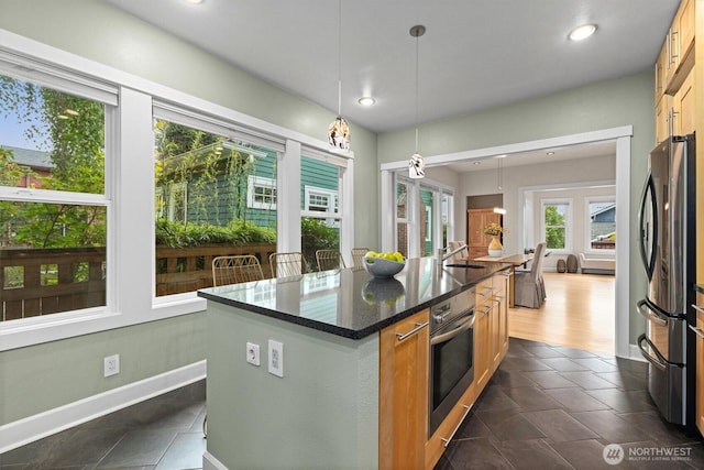 1218 NE 69th St, Seattle, WA 98115 - kitchen with stainless steel appliances, a kitchen island, decorative light fixtures, dark stone counters, and recessed lighting