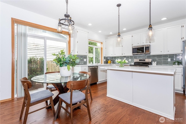 14808 26th Pl W Unit 2, Lynnwood, WA 98087 - kitchen with appliances with stainless steel finishes, light countertops, white cabinetry, decorative backsplash, and dark wood-style floors