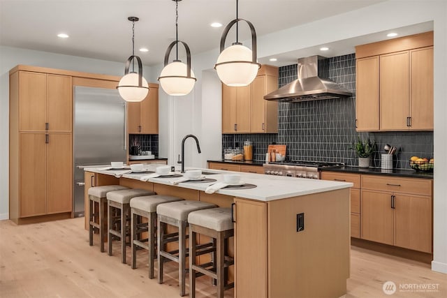 13321 108th Ave NE, Kirkland, WA 98034 - kitchen with wall chimney exhaust hood, built in refrigerator, light wood-style floors, a center island with sink, and decorative backsplash