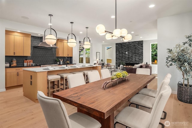 13321 108th Ave NE, Kirkland, WA 98034 - dining space featuring light wood finished floors, recessed lighting, a fireplace, baseboards, and a chandelier