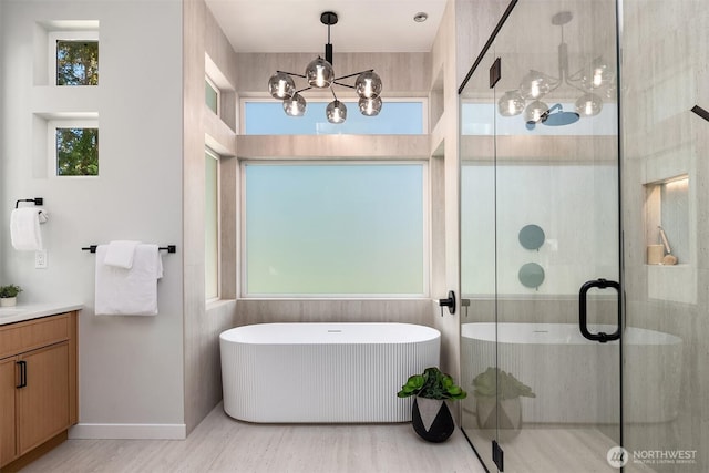 13321 108th Ave NE, Kirkland, WA 98034 - full bathroom with a chandelier, a freestanding tub, vanity, a stall shower, and wood finished floors
