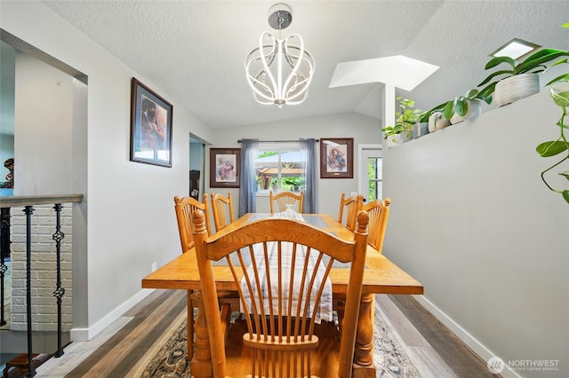 513 SE Highland Park Dr, College Place, WA 99324 - dining area with wood finished floors, a chandelier, baseboards, vaulted ceiling, and a textured ceiling