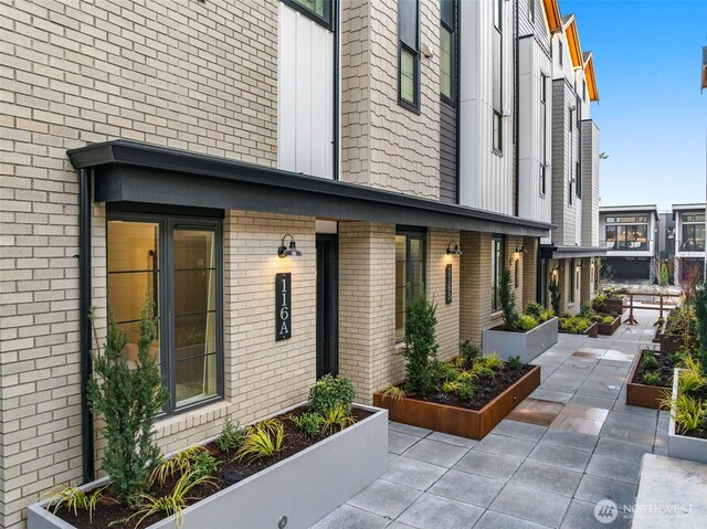 112F 2nd St S, Kirkland, WA 98033 - view of property exterior featuring brick siding and a garden