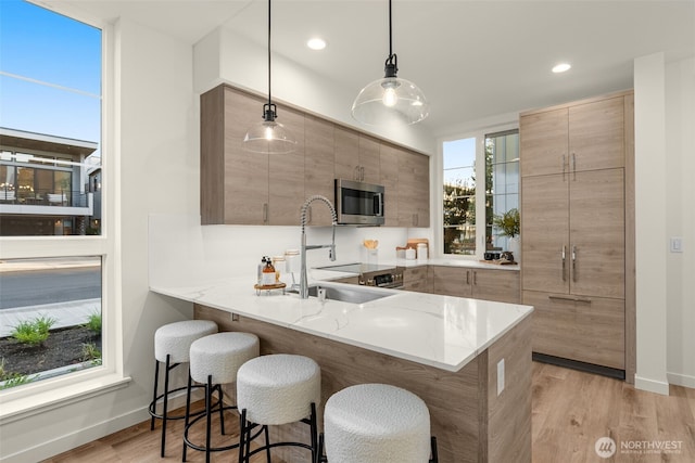 112F 2nd St S, Kirkland, WA 98033 - kitchen featuring stainless steel microwave, modern cabinets, a breakfast bar, a sink, and recessed lighting