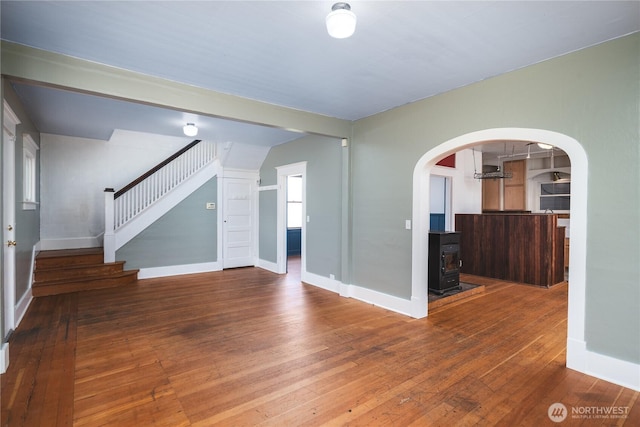 19719 Dry Slough Rd, Mount Vernon, WA 98273 - unfurnished living room with a wood stove, stairs, hardwood / wood-style flooring, baseboards, and arched walkways