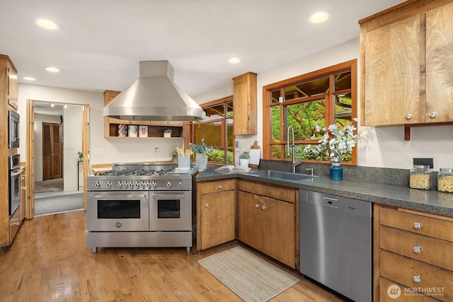 8509 NE 27th Pl, Clyde Hill, WA 98004 - kitchen featuring appliances with stainless steel finishes, island exhaust hood, light wood finished floors, dark countertops, and recessed lighting