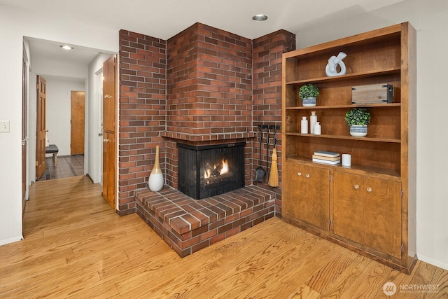 8509 NE 27th Pl, Clyde Hill, WA 98004 - unfurnished living room featuring light wood-type flooring, a brick fireplace, and recessed lighting