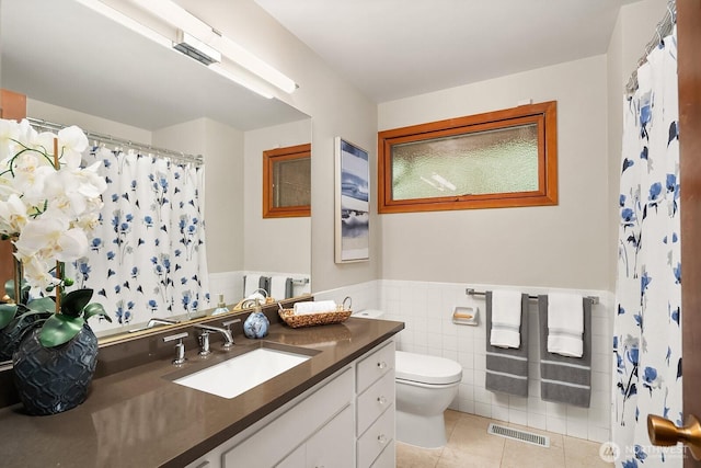 8509 NE 27th Pl, Clyde Hill, WA 98004 - full bathroom featuring tile patterned flooring, vanity, a wainscoted wall, tile walls, and a shower with curtain