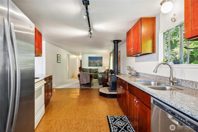 70 E Rustle Way, Grapeview, WA 98546 - kitchen with stainless steel appliances, a wood stove, a sink, open floor plan, and rail lighting