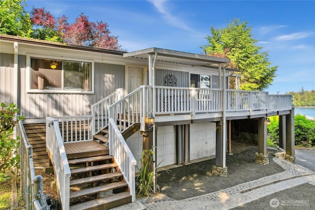 70 E Rustle Way, Grapeview, WA 98546 - view of front facade featuring an attached garage, dirt driveway, a wooden deck, and stairs