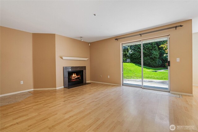 7453 Newcastle Golf Club Rd Unit B103, Newcastle, WA 98059 - unfurnished living room with light wood-type flooring, a fireplace, and baseboards