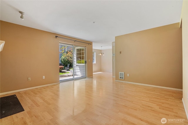 7453 Newcastle Golf Club Rd Unit B103, Newcastle, WA 98059 - spare room with light wood finished floors, baseboards, and a chandelier