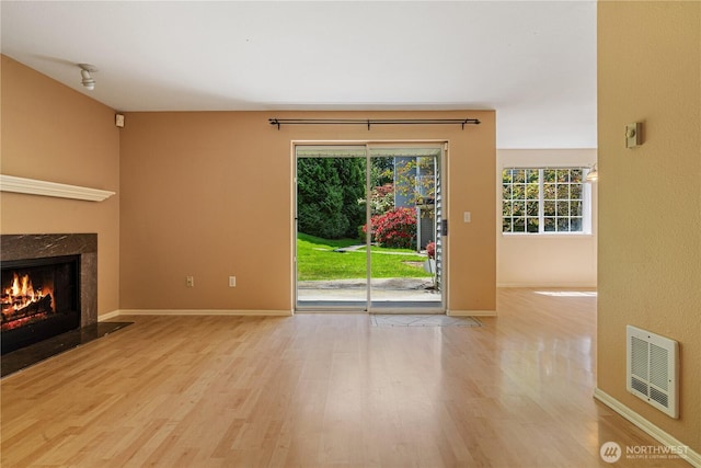 7453 Newcastle Golf Club Rd Unit B103, Newcastle, WA 98059 - unfurnished living room featuring wood finished floors, a premium fireplace, and baseboards