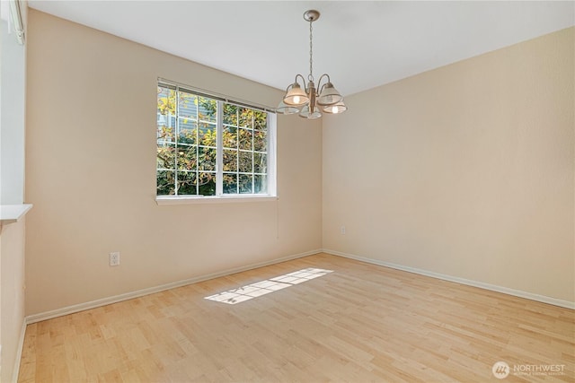 7453 Newcastle Golf Club Rd Unit B103, Newcastle, WA 98059 - spare room featuring a chandelier, wood finished floors, and baseboards