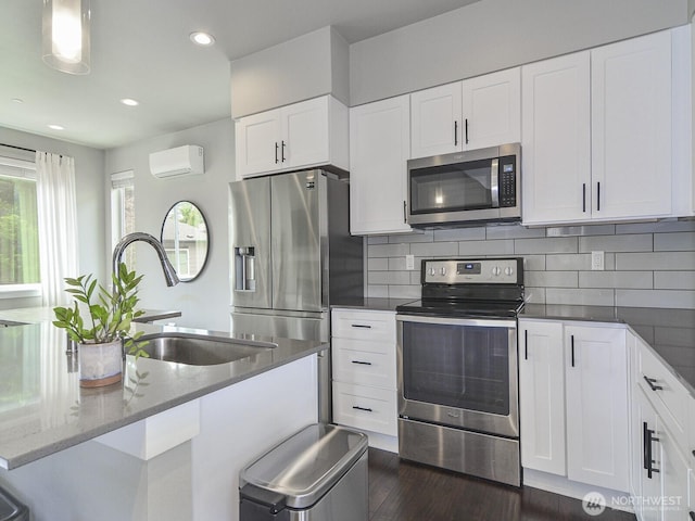3230 148th St SW Unit C1, Lynnwood, WA 98087 - kitchen featuring stainless steel appliances, a wall unit AC, a sink, dark wood-style flooring, and white cabinets