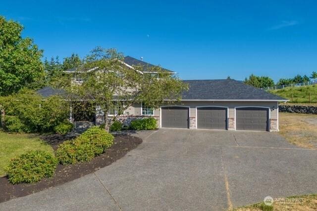 9906 328th St E, Graham, WA 98338 - view of front of house featuring a garage and asphalt driveway