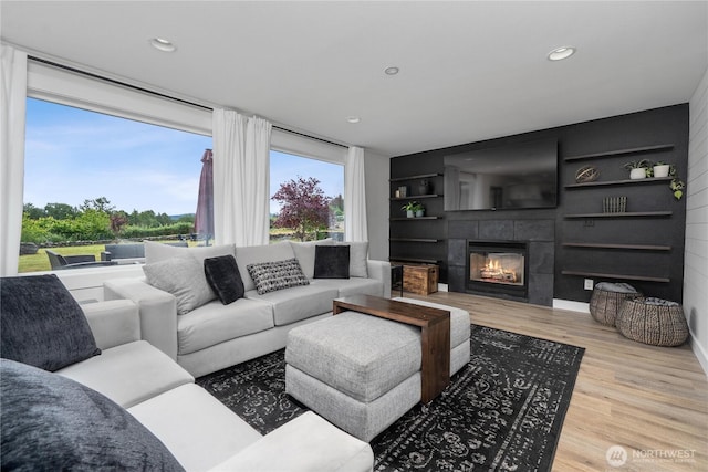 9906 328th St E, Graham, WA 98338 - living area with wood finished floors, a tiled fireplace, and recessed lighting