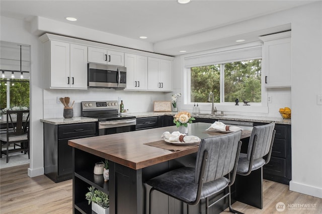 9906 328th St E, Graham, WA 98338 - kitchen featuring appliances with stainless steel finishes, wood counters, a sink, white cabinetry, and recessed lighting