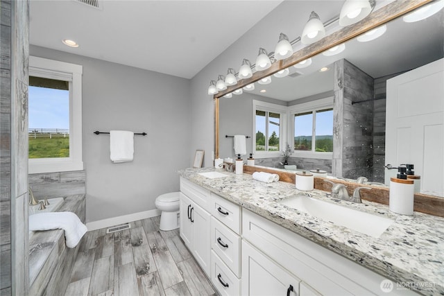9906 328th St E, Graham, WA 98338 - full bathroom featuring double vanity, baseboards, a bath, toilet, and tiled shower