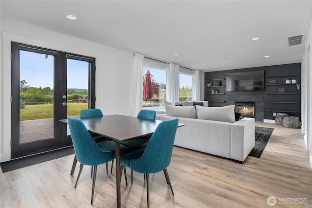 9906 328th St E, Graham, WA 98338 - dining room featuring french doors, light wood finished floors, recessed lighting, and a tile fireplace
