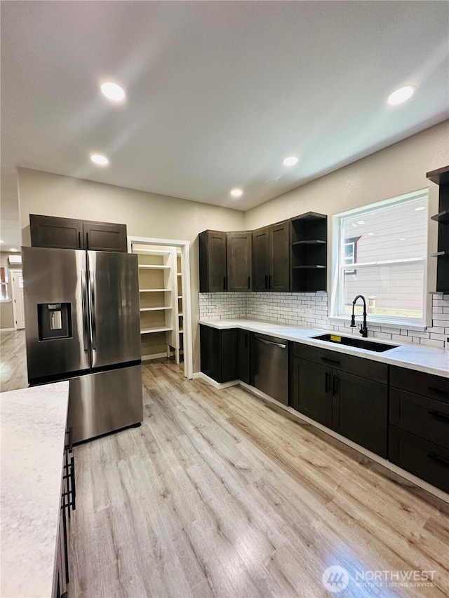 511 Baila Way, Aberdeen, WA 98520 - kitchen featuring stainless steel appliances, a sink, open shelves, backsplash, and light wood-style floors