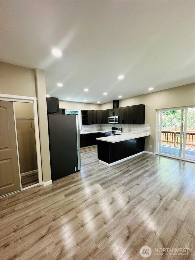 511 Baila Way, Aberdeen, WA 98520 - kitchen with appliances with stainless steel finishes, dark cabinets, a peninsula, light countertops, and light wood-style floors