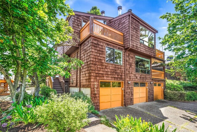 4618 3rd Ave NW, Seattle, WA 98107 - view of side of property with a balcony, a garage, asphalt driveway, and stairway