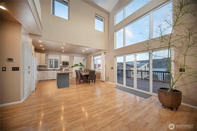 1071 S Section Pl, Quincy, WA 98848 - kitchen featuring stainless steel microwave, a center island, light wood-style flooring, white cabinets, and freestanding refrigerator