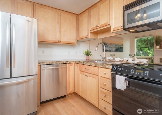 301 W Raye St Unit 105, Seattle, WA 98119 - kitchen with appliances with stainless steel finishes, light brown cabinets, a sink, and light wood finished floors