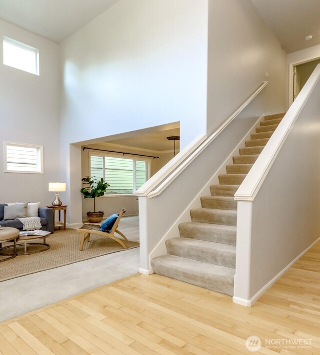 1913 NE 32nd St, Renton, WA 98056 - staircase with wood-type flooring, a high ceiling, plenty of natural light, and baseboards