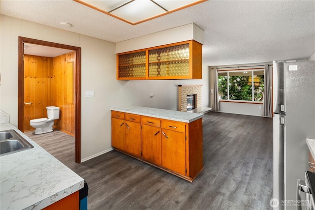 16327 Smokey Point Blvd Unit 1 & 2, Marysville, WA 98271 - kitchen with dark wood-style flooring, light countertops, freestanding refrigerator, brown cabinets, and a textured ceiling