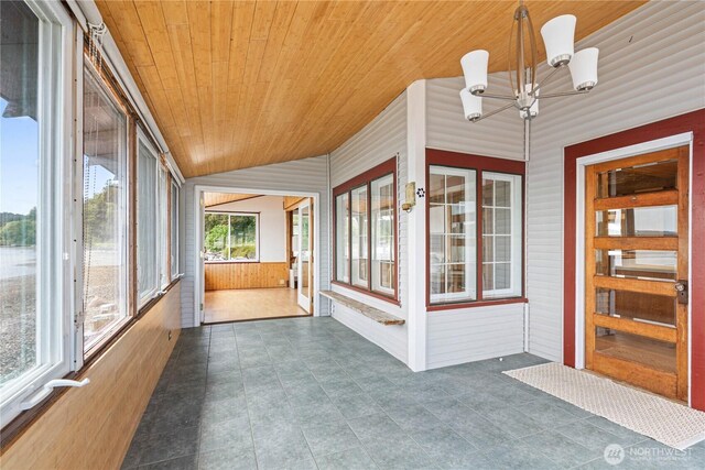 24186 Vashon Hwy SW, Vashon, WA 98070 - unfurnished sunroom featuring wood ceiling, a chandelier, wooden walls, and tile patterned floors