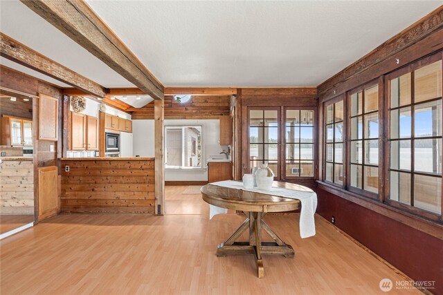 24186 Vashon Hwy SW, Vashon, WA 98070 - dining room featuring wood walls, light wood-style flooring, and beam ceiling