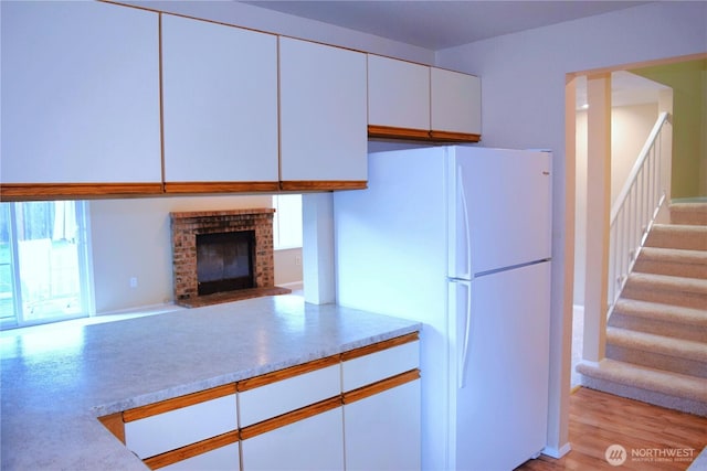 2113 186th Pl SE, Bothell, WA 98012 - kitchen with freestanding refrigerator, white cabinetry, light countertops, a fireplace, and open floor plan