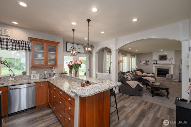 331 Viewmont Dr SE, Moses Lake, WA 98837 - kitchen with dishwasher, brown cabinets, a peninsula, a breakfast bar area, and glass insert cabinets