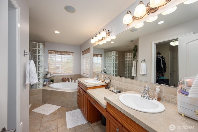 331 Viewmont Dr SE, Moses Lake, WA 98837 - bathroom featuring double vanity, a bath, tile patterned floors, a walk in closet, and tiled shower