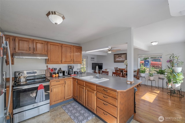 1011 N Dolfay Ln, East Wenatchee, WA 98802 - kitchen with stainless steel range with electric cooktop, under cabinet range hood, a sink, a peninsula, and a ceiling fan