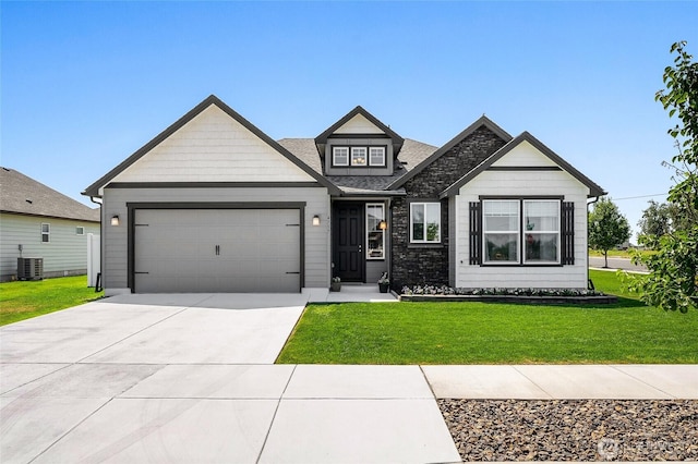4737 W Owl St, Moses Lake, WA 98837 - view of front of home featuring a garage, central air condition unit, a front lawn, concrete driveway, and a shingled roof
