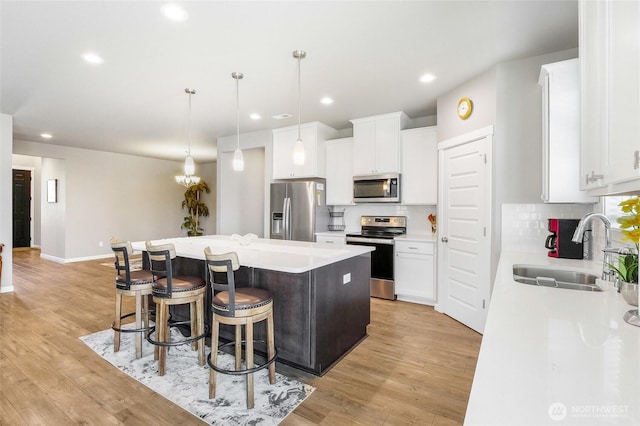 4737 W Owl St, Moses Lake, WA 98837 - kitchen with stainless steel appliances, a sink, a kitchen island, tasteful backsplash, and a kitchen breakfast bar