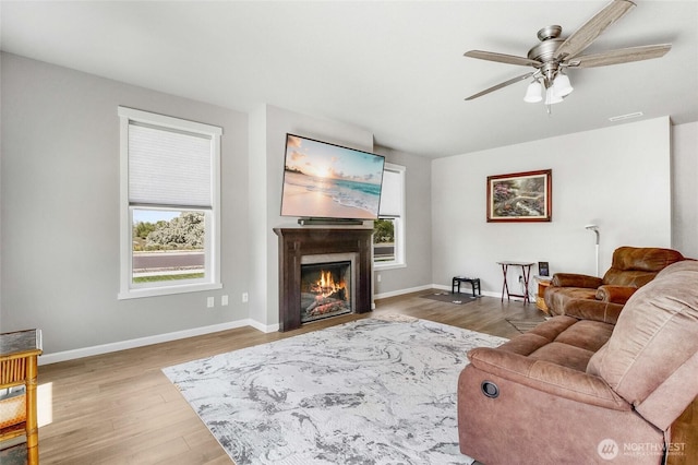 4737 W Owl St, Moses Lake, WA 98837 - living room with a ceiling fan, wood finished floors, a glass covered fireplace, and baseboards