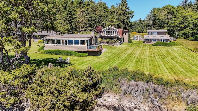 62 Wildwood Ln, Lopez Island, WA 98261 - rear view of property featuring a sunroom, a yard, a metal roof, and a wooded view
