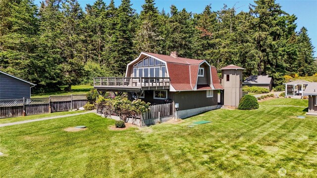 62 Wildwood Ln, Lopez Island, WA 98261 - back of property featuring a gambrel roof, a wooden deck, and a chimney