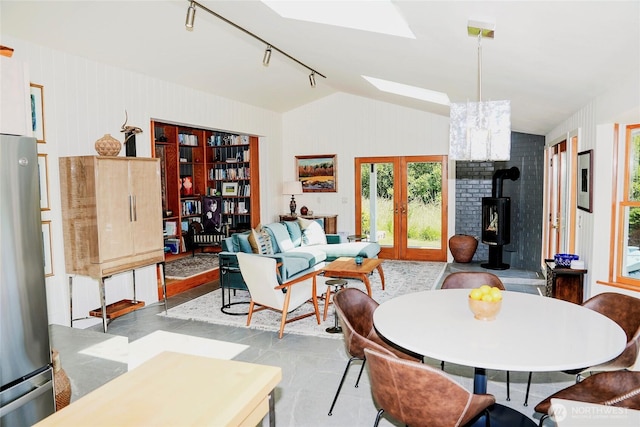 62 Wildwood Ln, Lopez Island, WA 98261 - dining area with vaulted ceiling, a wood stove, french doors, a skylight, and track lighting