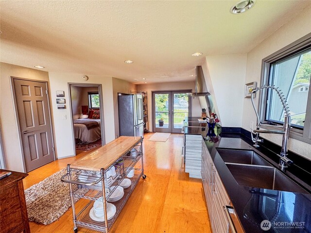 62 Wildwood Ln, Lopez Island, WA 98261 - kitchen with freestanding refrigerator, light wood finished floors, french doors, recessed lighting, and dark countertops