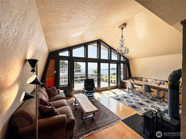 62 Wildwood Ln, Lopez Island, WA 98261 - living area with wood finished floors, lofted ceiling, a textured wall, a textured ceiling, and a chandelier
