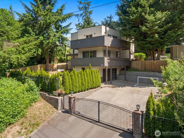 16422 76th Ave NE, Kenmore, WA 98028 - view of front of home with a gate, a balcony, concrete driveway, and a garage