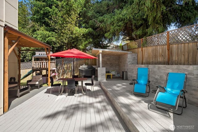 16422 76th Ave NE, Kenmore, WA 98028 - wooden deck with a playground, outdoor dining space, a fenced backyard, and grilling area