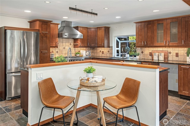 2942 222nd Pl SE, Sammamish, WA 98075 - kitchen with freestanding refrigerator, wall chimney range hood, a breakfast bar area, stone tile floors, and recessed lighting