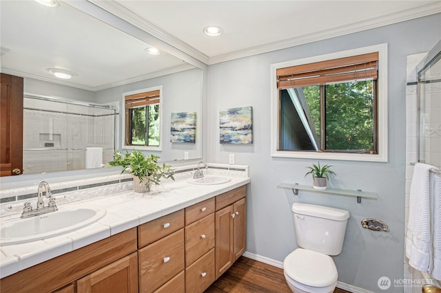 2942 222nd Pl SE, Sammamish, WA 98075 - bathroom featuring double vanity, ornamental molding, tiled shower, toilet, and wood finished floors