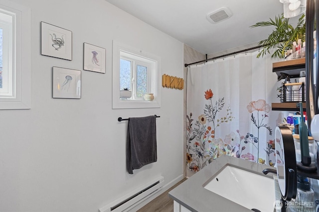 2702 16th St, Everett, WA 98201 - bathroom with a baseboard heating unit, vanity, wood finished floors, baseboards, and a shower with shower curtain